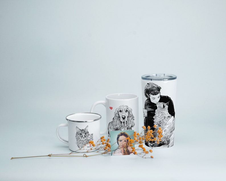 May include: Three white mugs with black and white illustrations of a cat, a dog, and a person with a cat. The mugs are on a white surface with dried flowers.