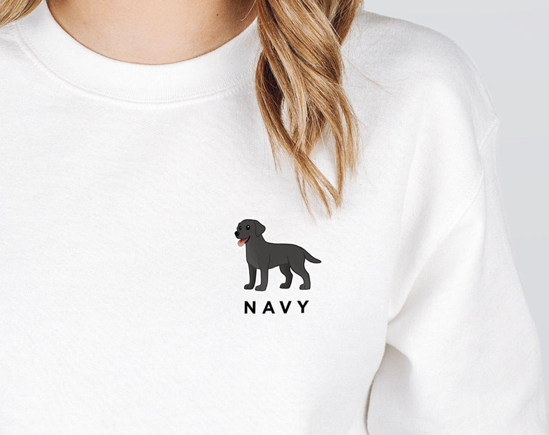 Pode incluir: Camisola branca com uma ilustra&ccedil;&atilde;o de um Labrador Retriever preto de desenho animado e a palavra "NAVY" impressa abaixo.