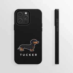 K&ouml;nnte beinhalten: Schwarze Handyh&uuml;lle mit einem Cartoon-Dackel und dem Namen "TUCKER" darauf.