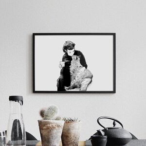 May include: Black and white illustration of a person holding a cat. The person is wearing a hat and holding a cup. The cat is looking up at the person.