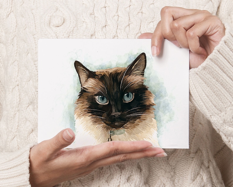 K&ouml;nnte beinhalten: Ein Aquarellbild eines braunen und wei&szlig;en Katers mit blauen Augen. Der Kater schaut den Betrachter mit einem ernsten Ausdruck direkt an. Der Hintergrund ist ein weicher blauer und gr&uuml;ner Aquarell-Wasch.