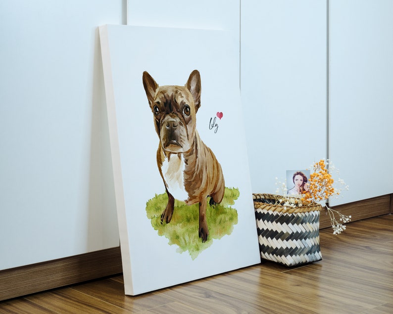 Puede incluir: Una pintura de acuarela de un Bulldog Franc&eacute;s marr&oacute;n y blanco sentado en un parche de hierba verde. El perro est&aacute; mirando directamente al espectador. La pintura est&aacute; en un lienzo blanco y tiene el nombre "Lily" escrito en cursiva junto a un coraz&oacute;n rojo.