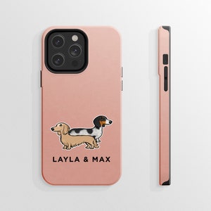 K&ouml;nnte beinhalten: Eine rosa Handyh&uuml;lle mit einer Cartoon-Abbildung von zwei Dackeln, einem schwarz-wei&szlig;em und einem braunen, mit dem Text "LAYLA & MAX".