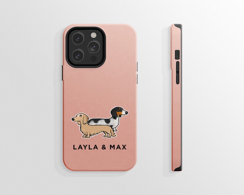 K&ouml;nnte beinhalten: Eine rosa Handyh&uuml;lle mit einer Cartoon-Abbildung von zwei Dackeln, einem schwarz-wei&szlig;em und einem braunen, mit dem Text "LAYLA & MAX".