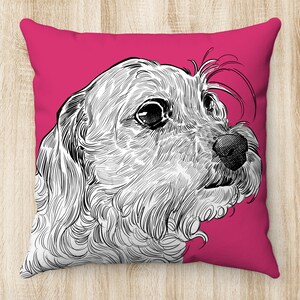May include: A pink pillow with a black and white line drawing of a dog's head. The dog is looking to the right and has a fluffy, curly coat.