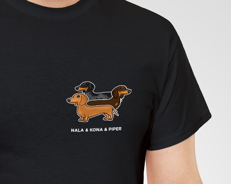 May include: Black t-shirt featuring a graphic of three dachshund dogs in brown, black, and tan. The text "NALA & KONA & PIPER" is printed below the dogs in white. The shirt is made of a soft material.
