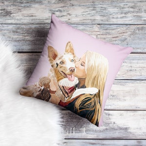 May include: A pink throw pillow with a watercolor illustration of a woman kissing a dog. The dog is brown and white with blue eyes. The woman has long blonde hair.