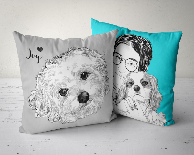 May include: Two gray and white throw pillows with black and white illustrations of dogs. One pillow has the word "Joy" printed on it. The other pillow has a person with glasses holding a dog.