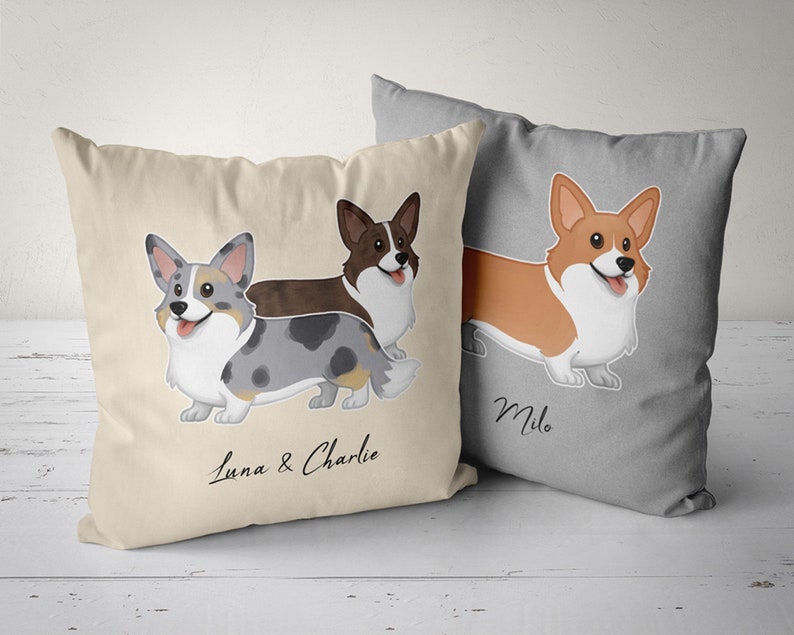 May include: Two beige throw pillows with cartoon images of Corgi dogs. One pillow features two Corgis with the names "Luna & Charlie" and the other pillow features one Corgi with the name "Milo".