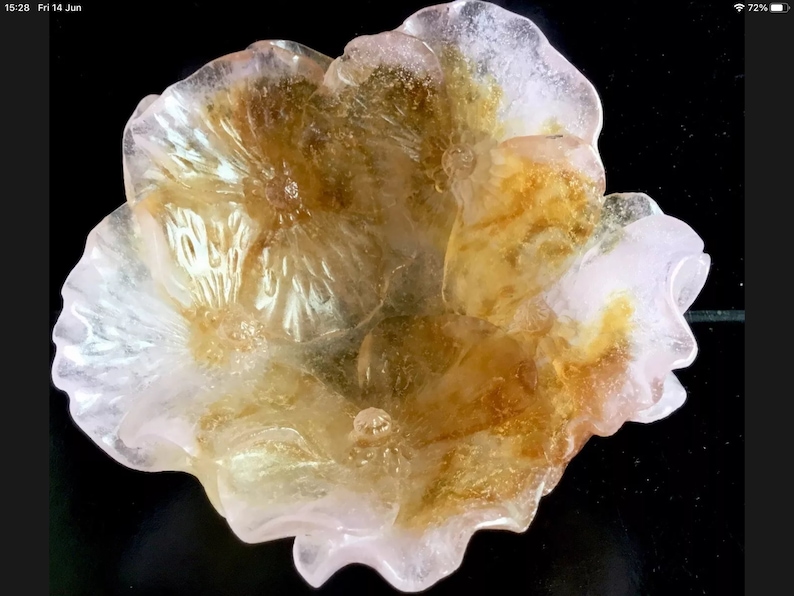 May include: A delicate, translucent flower-shaped bowl made of glass. The bowl has a pink and yellow color scheme with intricate details.