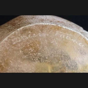 May include: Close-up of a clear glass bowl with a textured surface. The bowl has a faint inscription that reads "Cristal de Baccarat".
