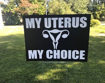 Könnte beinhalten: Schwarz-weißes Schild mit dem Text "MY UTERUS MY CHOICE" und einer weißen Silhouette einer Gebärmutter.
