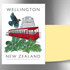 May include: A red and white cable car with the words "Wellington Cable Car" on the side, a blue and white bird flying above, and a gray building in the background. The text "WELLINGTON" is at the top of the image and "NEW ZEALAND" is at the bottom. The text "Artwork by New Zealand artist Jade Ell tuironottui.com" is at the bottom of the image.