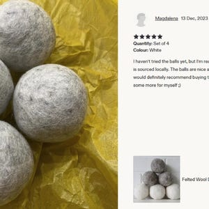 Felted wool dryer balls stacked in white and gray against a white brick wall; natural, allergy-free, eco-friendly fabric softener.