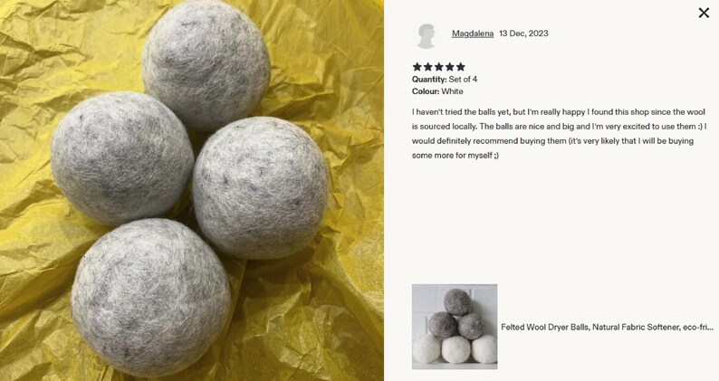 Felted wool dryer balls stacked in white and gray against a white brick wall; natural, allergy-free, eco-friendly fabric softener.