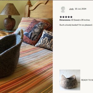 Felted wool storage basket in grey with two wrapped handles; cozy cat bed with a sleeping cat inside.