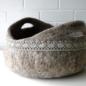Felted storage basket with linen lace trim and handles; neutral brown felt, ideal as magazine bin or cat bed.