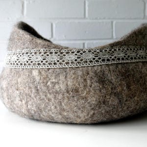 Felted storage basket with linen lace trim and handles; neutral brown felt, ideal as magazine bin or cat bed.
