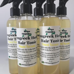 Könnte beinhalten: Fünf durchsichtige Kunststoff-Sprühflaschen mit einer hellgelben Haar-Tonic-Flüssigkeit. Jede Flasche hat ein weißes Etikett mit dem Text Brina Organics Fenugreek Herb Hair Tonic, Potent Formula, und einer Füllmenge von 8 oz.