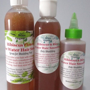 May include: Three clear plastic bottles of Brina Organics Hibiscus & Rice Water Hair Smoothie. The bottles are labeled with ingredients and instructions, featuring sizes of 8 oz., 6 oz., and 4 oz. The liquid inside is a translucent reddish-brown color.