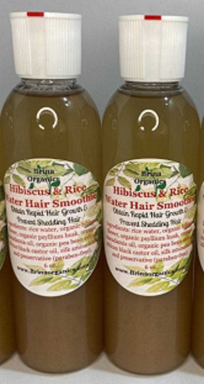 May include: Two clear plastic bottles filled with a light brown liquid hair treatment. Each bottle has a white cap and a label reading Bruna Organics Hibiscus & Rice Water Hair Smoothie, Obtain Rapid Hair Growth & Prevent Shedding Hair, 6 oz.