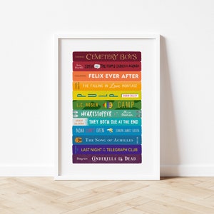 Könnte beinhalten: Ein gerahmter Druck mit einem Stapel bunter Buchrücken. Zu den Titeln gehören "Cemetery Boys", "Felix Ever After" und "The Song of Achilles". Die Buchrücken sind in einem Regenbogen-Farbverlauf angeordnet, was eine ansprechende Darstellung ergibt.