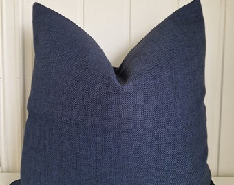 May include: A dark blue square cushion with a textured fabric.