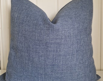 Peut inclure: Un coussin bleu avec un tissu texturé. Le coussin est carré et a un design simple.