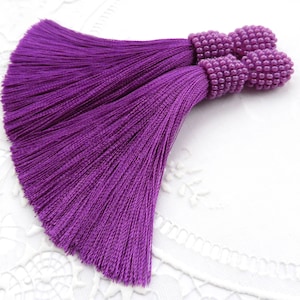 Violetta örhängen med sidentofsar Lila klämmörhängen Långa örhängen med pärltofsar Oscar de la renta örhängen Oscar örhängen Örhängen med seed beads