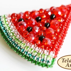 May include: A watermelon slice brooch made of red, green, and black beads. The brooch is shaped like a slice of watermelon with a green rind and red flesh. The seeds are represented by black beads.