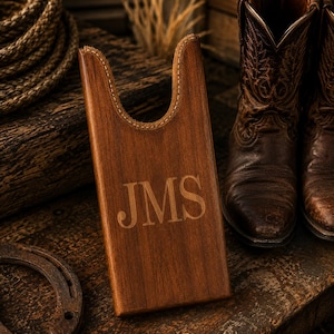 May include: A rectangular brown wooden boot jack with a U-shaped cutout at the top for heel removal. The front surface features the engraved letters JMS in a serif font. The wood has a visible grain and a smooth, polished finish throughout.