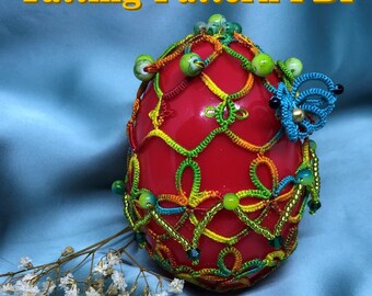 May include: A red egg covered in a colorful crocheted pattern with green, yellow, and blue thread. The egg is decorated with beads and a small blue butterfly. The text "Tatting Pattern PDF" and "Shuttle tatting" is visible in the image.