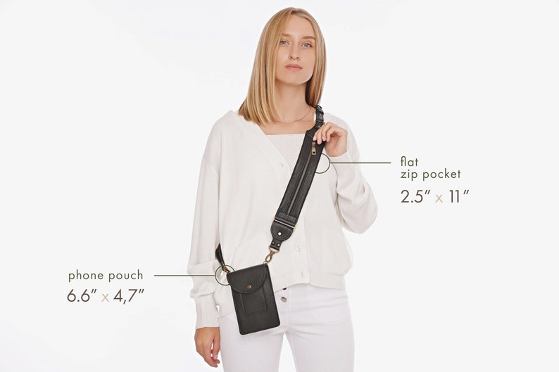 May include: A black crossbody bag with a phone pouch measuring 6.6 inches by 4.7 inches and a wide shoulder strap featuring a flat zip pocket measuring 2.5 inches by 11 inches. The bag has a snap button closure and brass-toned hardware.