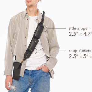 May include: A black leather shoulder strap accessory featuring two attached pouches. One pouch has a side zipper measuring 2.5 inches by 4.7 inches by 0.7 inches, and the other has a snap closure measuring 2.5 inches by 5 inches by 1 inch.