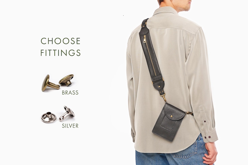 May include: A black leather crossbody phone pouch with a wide shoulder strap featuring a vertical zippered pocket. The text CHOOSE FITTINGS appears next to two metal button options: brass and silver, shown as two-piece sets for attachment.
