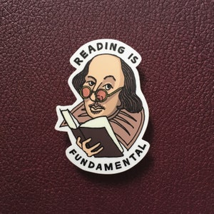 Sticker featuring a hand-drawn William Shakespeare illustration, resting on a brown leather book. He's surrounded by the phrase READING IS FUNDAMENTAL, referencing the film Paris Is Burning and RuPaul's Drag Race's reading challenge.