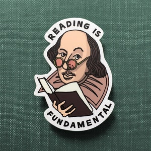 Matte sticker resting on a green, clothbound book. The sticker features an illustration of  William Shakespeare, wearing pink-tinted glasses, as he holds a book. His right eyebrow is cocked while making a deadpan expression at you.
