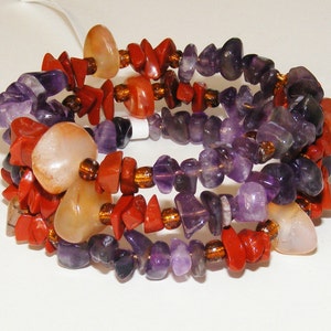 May include: Multi-strand bracelet featuring amethyst, carnelian, and red jasper beads. The bracelet is made of natural stones and has a bohemian style.