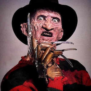 May include: A character with a scarred, textured face wearing a black fedora and a red and black horizontally striped sweater. The character has a metallic glove with long, sharp, curved blades attached to the fingers, positioned near the face.