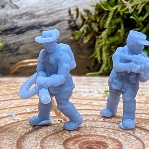 May include: Seven blue plastic toy figures of soldiers, each holding a weapon, standing on a wooden surface.