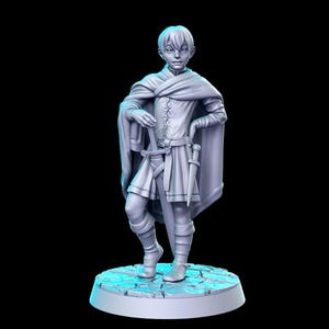 May include: A 3D-printed figurine of a young person in medieval attire. The figure wears a tunic, cape, and boots, with a sword and dagger at their side. The figure is standing on a circular base with a cobblestone texture, against a black background.