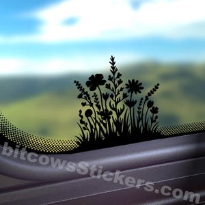 May include: A black vinyl decal featuring a silhouette of various wildflowers and grasses, applied to a glass surface. The design includes diverse floral shapes and stems. The text bitcowsStickers.com is visible in white at the bottom.