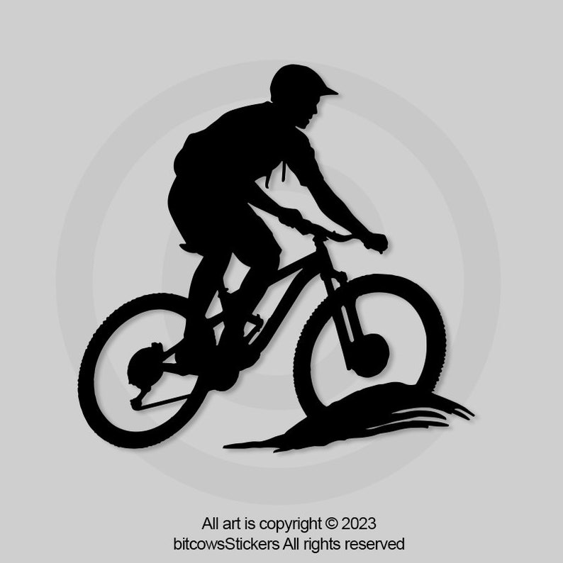 May include: Silhouette of a person riding a mountain bike on a dirt path. The rider is wearing a helmet and is in mid-air.