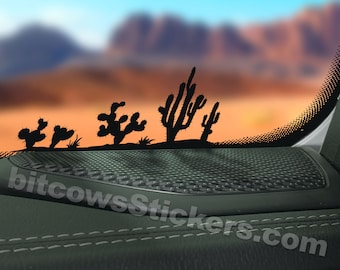 May include: Black silhouette of cactus plants on a car window. The window is partially open and the car interior is visible. The car interior is black with a black speaker grill.