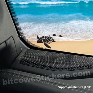 May include: Black silhouette of a sea turtle and two fish swimming on a sandy beach with blue ocean waves in the background. The image is a sticker for a car window. *Approximate Size 3.50*"