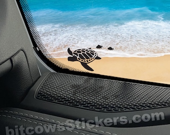 May include: Black silhouette of a sea turtle and two fish swimming on a sandy beach with blue ocean waves in the background. The image is a sticker for a car window. *Approximate Size 3.50*"