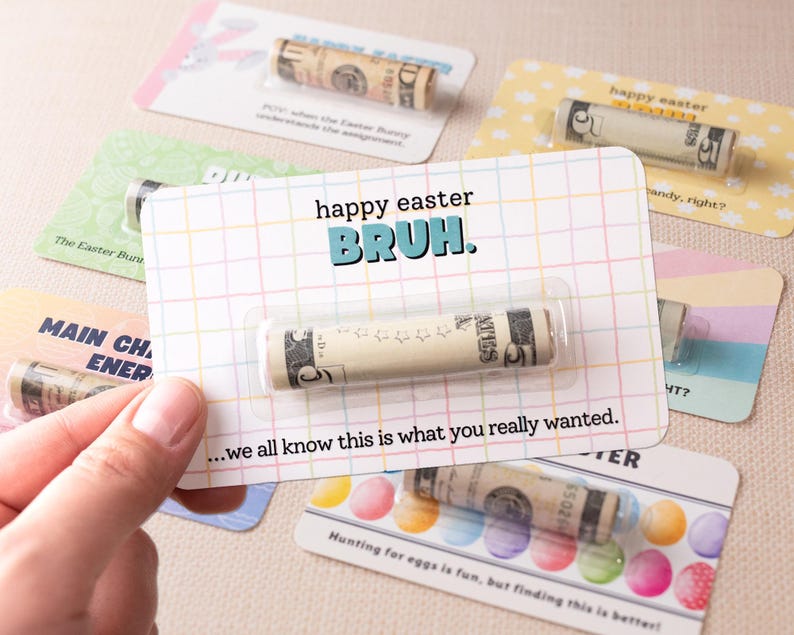 May include: A colorful card with the text "happy easter BRUH." and a rolled up $5 bill inside a plastic sleeve. The card is surrounded by other cards with similar designs.