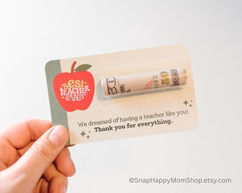 May include: A red apple with the words "Best Teacher Ever" on it. A rolled up bill of money is attached to the card. The card says "We dreamed of having a teacher like you! Thank you for everything."
