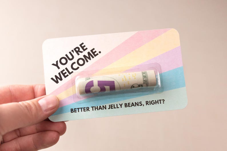 A hand holding a card with rolled money in it