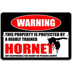 Puede incluir: Un letrero rectangular negro con texto blanco y rojo que dice "WARNING" y "HORNET". El letrero también dice "THIS PROPERTY IS PROTECTED BY A HIGHLY TRAINED HORNET" y "NOT RESPONSIBLE FOR INJURY OR POSSIBLE DEATH". Una silueta de un avispón a la derecha.